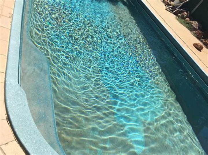 How do you remove brown stains from a gunite pool?